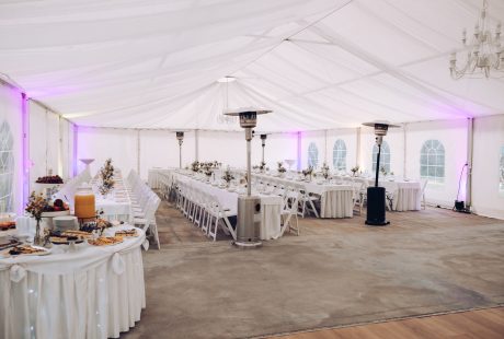 Location de salle de mariage : salle de réception décorée de fleurs et de lumières, tables dressées pour les invités