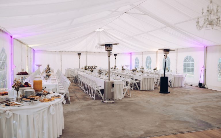 Location de salle de mariage : salle de réception décorée de fleurs et de lumières, tables dressées pour les invités