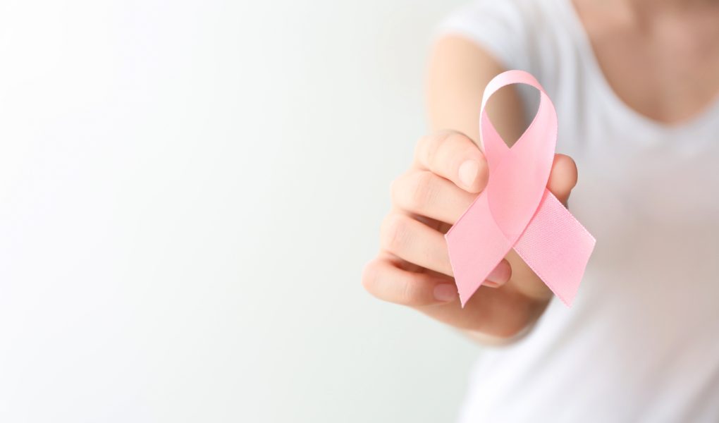 Femme tenant un ruban rose, symbole d'Octobre Rose et de la lutte contre le cancer du sein