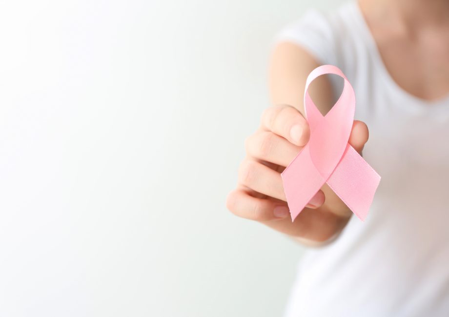 Femme tenant un ruban rose, symbole d'Octobre Rose et de la lutte contre le cancer du sein