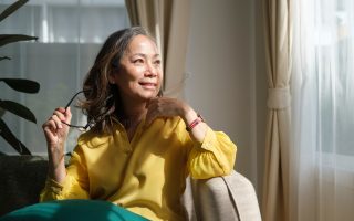 Femme d'âge mûr sereine sur son canapé, illustrant le bien-être pendant la ménopause