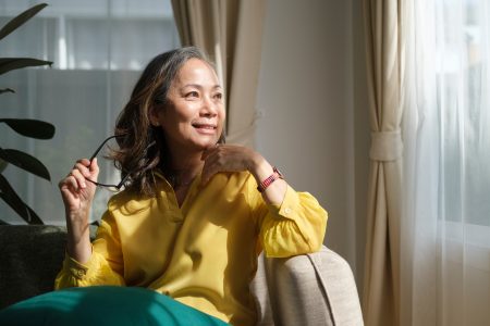 Femme d'âge mûr sereine sur son canapé, illustrant le bien-être pendant la ménopause