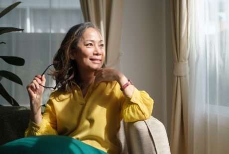 Femme d'âge mûr sereine sur son canapé, illustrant le bien-être pendant la ménopause