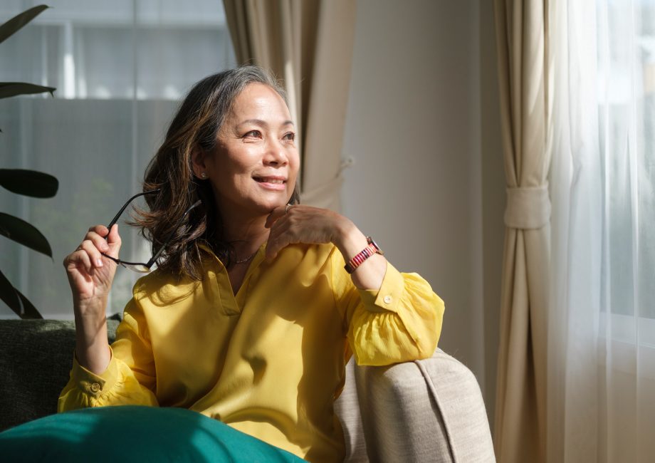 Femme d'âge mûr sereine sur son canapé, illustrant le bien-être pendant la ménopause