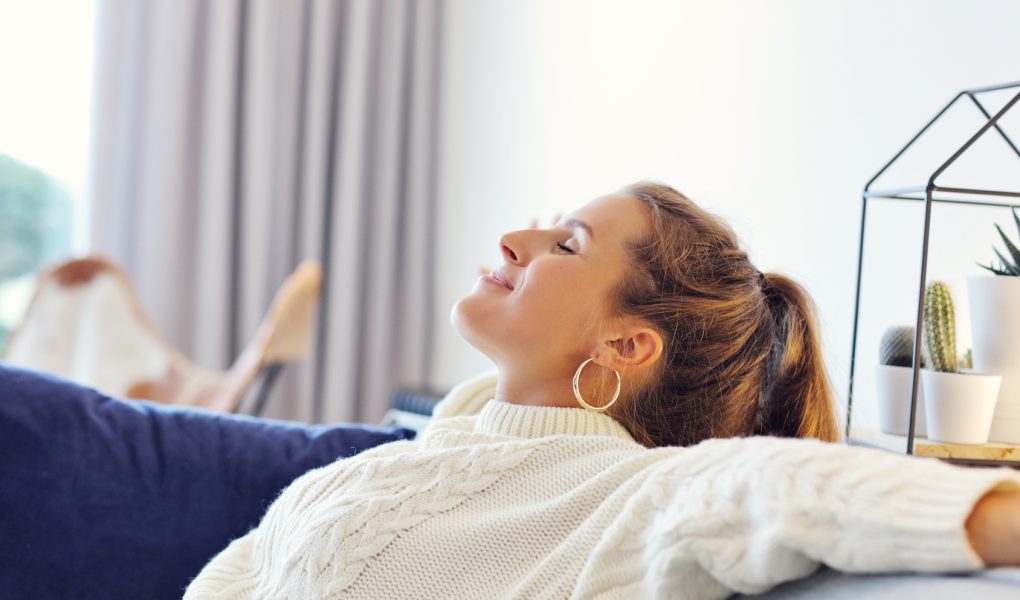 Santé mentale des femmes : une femme en pull douillet se repose chez elle par une journée d'automne