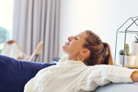 Santé mentale des femmes : une femme en pull douillet se repose chez elle par une journée d'automne